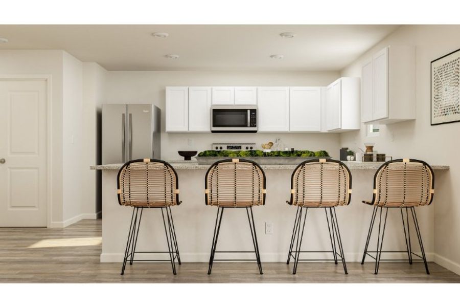 A kitchen with a bar stools and a table.
