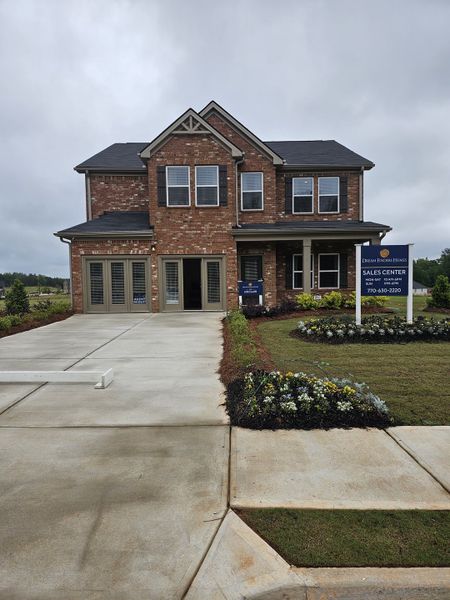 A charming brick home with a manicured lawn in Fern Dale by Dream Finders Homes (Fairburn, GA).
