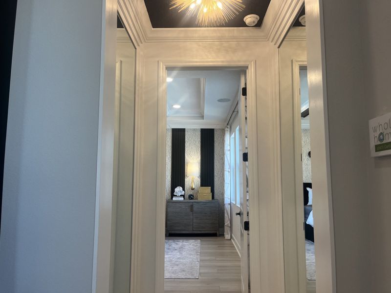 A luxurious hallway leading to an elegant room, featuring a modern light fixture and sleek design elements. A luxurious hallway leading to an elegant room, featuring a modern light fixture and sleek design elements.