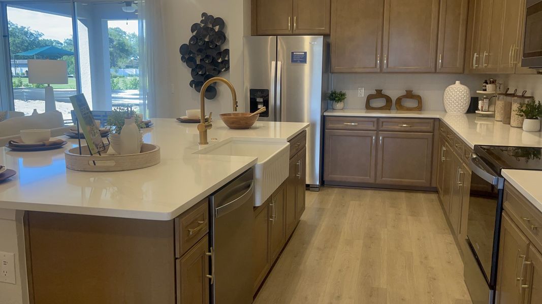 A modern kitchen with sleek stainless appliances, a farmhouse sink, and elegant cabinetry. A modern kitchen with sleek stainless appliances, a farmhouse sink, and elegant cabinetry.