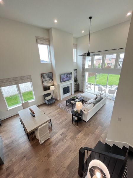 A spacious open-concept living area with hardwood floors, floor-to-ceiling windows, and modern furnishings. A spacious open-concept living area with hardwood floors, floor-to-ceiling windows, and modern furnishings.