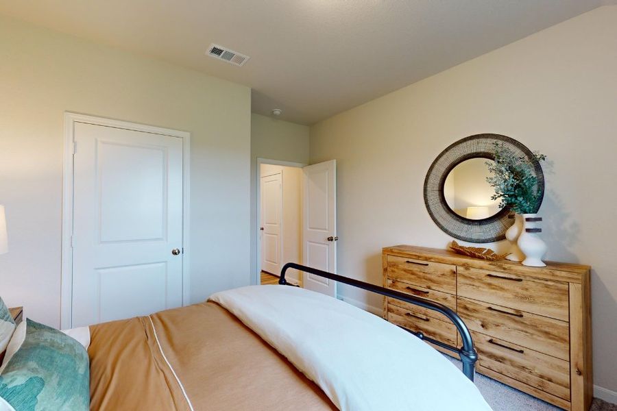 A bedroom with a mirror and a bed. A bedroom with a mirror and a bed.