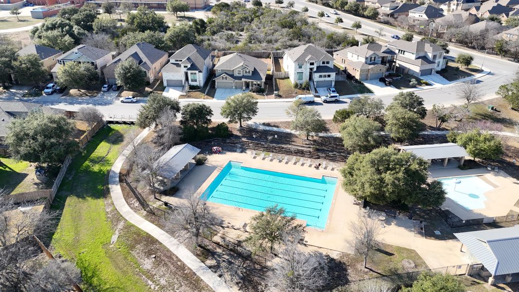 Aerial view of a charming neighborhood pool and park in Weston Oaks 55' by Perry Homes, nestled in San Antonio, TX.