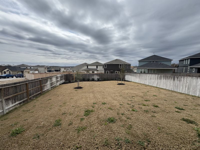Spacious fenced backyard with serene views in Hunters Ranch by Legend Homes, San Antonio, TX.