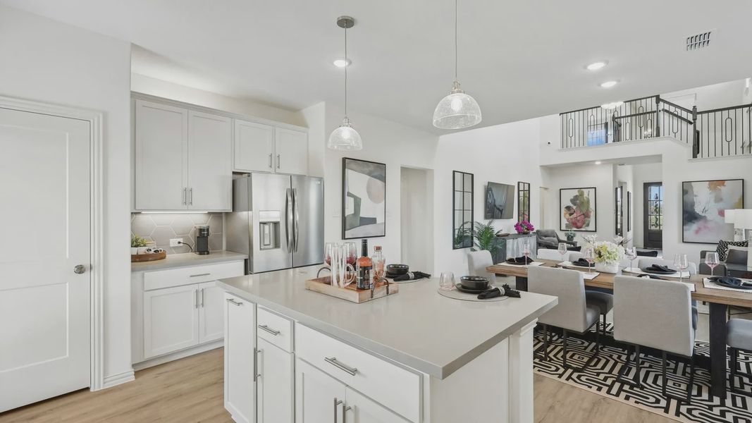 Sleek kitchen and dining with quartz counters, stainless steel, and high ceilings in Bel Air Village.