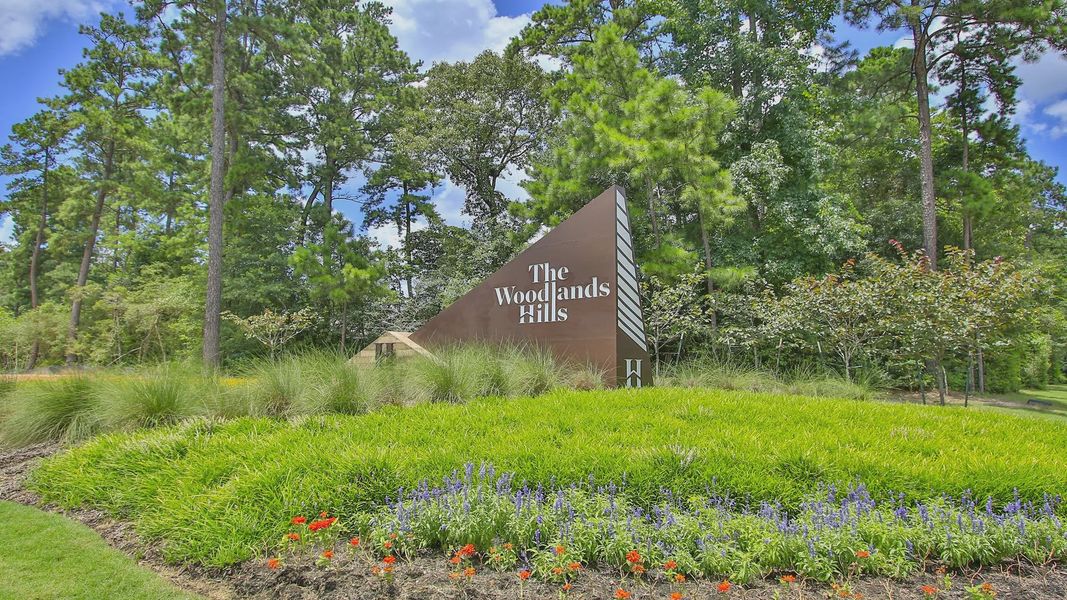 "Experience architectural elegance at The Woodlands Hills. Stunning signage complements the verdant landscape."