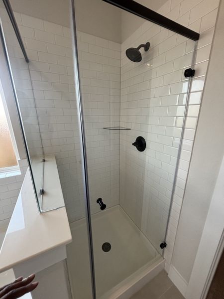 A sleek glass-enclosed shower with subway tile and black fixtures for a modern and elegant touch. A sleek glass-enclosed shower with subway tile and black fixtures for a modern and elegant touch.