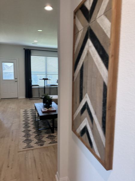 A cozy living area with patterned rug, elegant wall art, and natural light streaming through large windows. A cozy living area with patterned rug, elegant wall art, and natural light streaming through large windows.