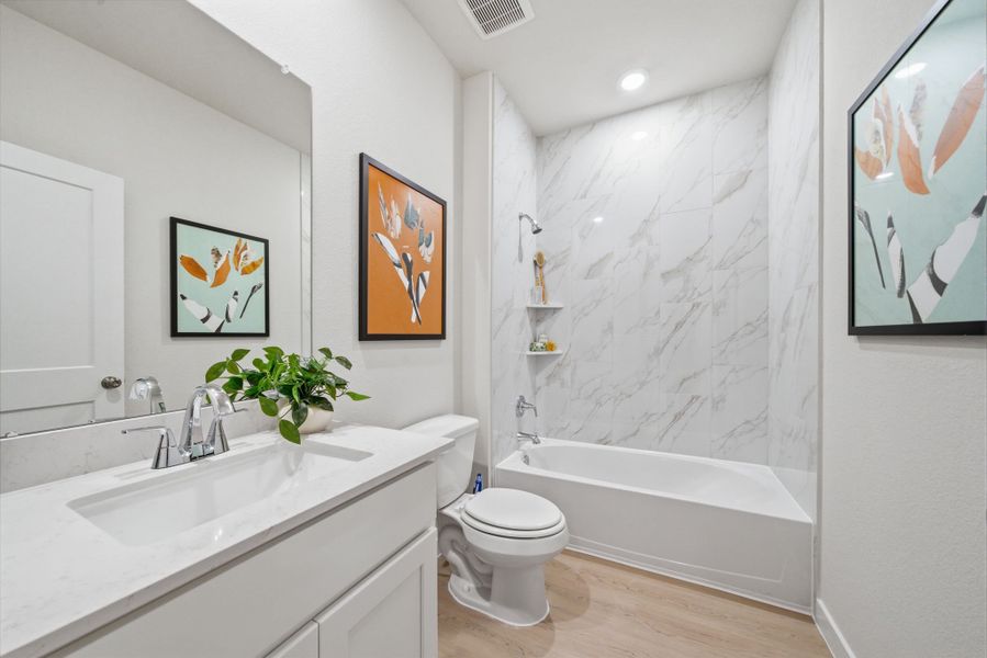 A bathroom with a tub toilet and sink. A bathroom with a tub toilet and sink.
