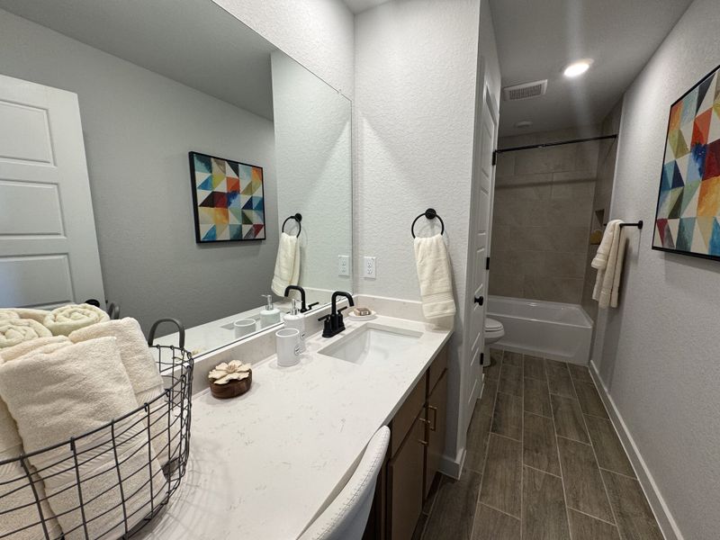 A modern bathroom featuring a sleek vanity, mosaic artwork, and elegant fixtures, offering both style and functionality. A modern bathroom featuring a sleek vanity, mosaic artwork, and elegant fixtures, offering both style and functionality.