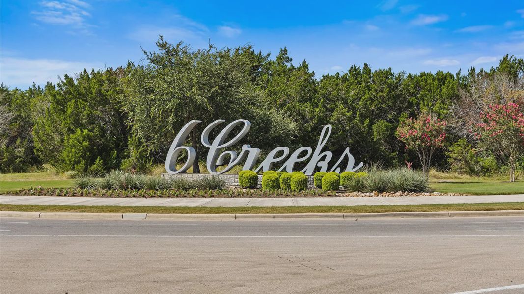 Entrance to the 6 Creeks community in Kyle, TX, featuring signage and landscaping (Image 2).