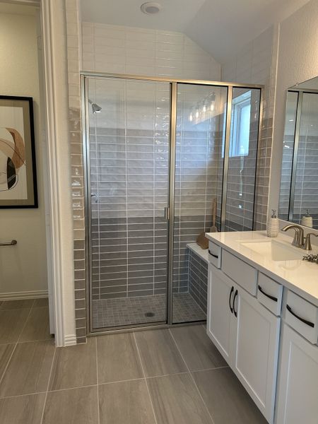 A modern bathroom featuring a glass-enclosed shower, elegant tile work, and a sleek white vanity with stylish black handles. A modern bathroom featuring a glass-enclosed shower, elegant tile work, and a sleek white vanity with stylish black handles.
