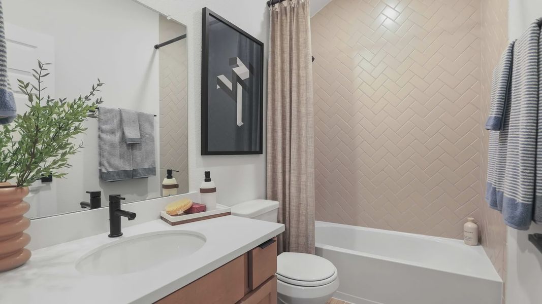 Luxurious herringbone tile and refined black fixtures elevate this Mostyn Springs bathroom design. Luxurious herringbone tile and refined black fixtures elevate this Mostyn Springs bathroom design.