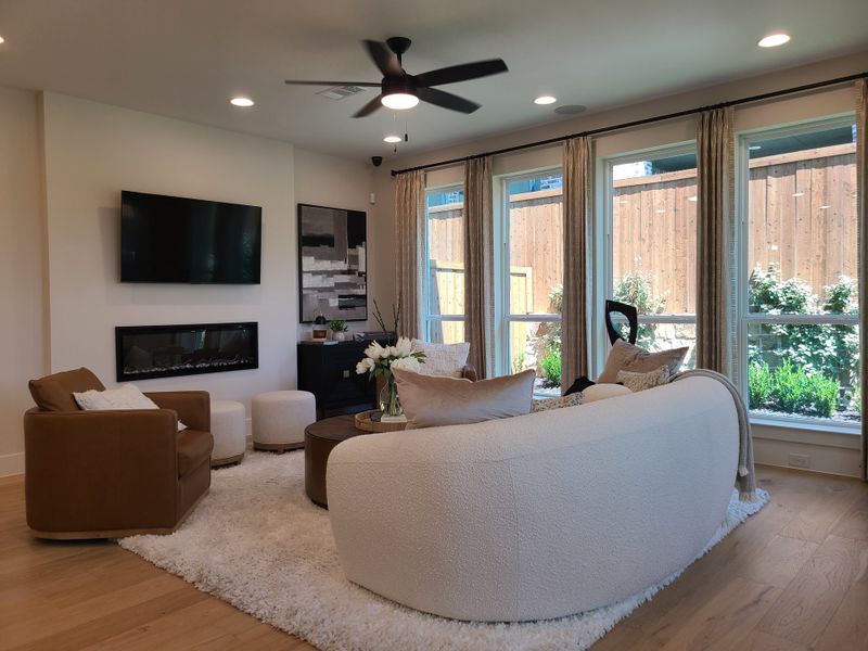 A cozy living room featuring a modern fireplace, plush seating, and large windows overlooking a landscaped garden. A cozy living room featuring a modern fireplace, plush seating, and large windows overlooking a landscaped garden.