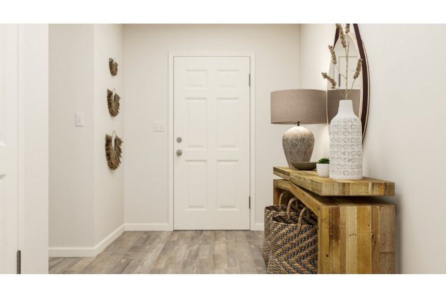 A room with a table and a lamp and a white door.