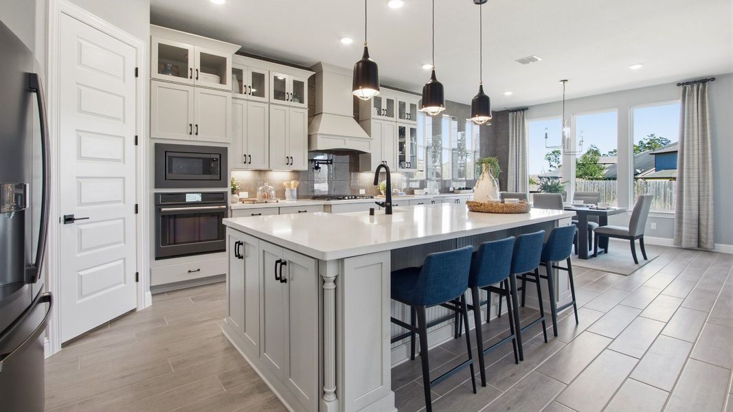 Elegant cabinetry and quartz island enhance this kitchen's luxurious ambiance in Mostyn Manor Reserve.