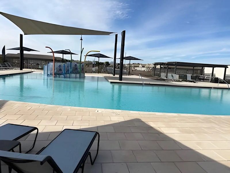 A luxurious community pool with shaded lounging area and modern design. Perfect for relaxing and family fun. A luxurious community pool with shaded lounging area and modern design. Perfect for relaxing and family fun.