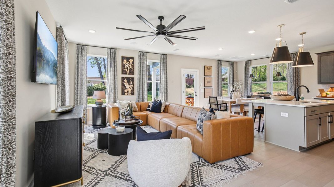 Open Concept first floor layout with cozy living room, kitchen island, and dining area near the back door