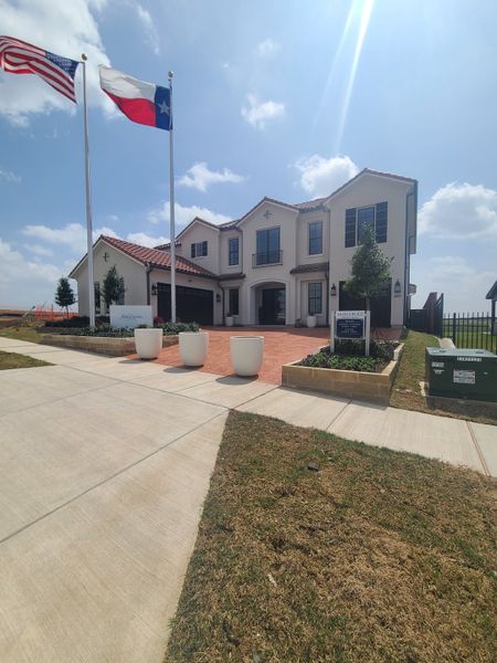 A beautiful two-story home with a red-tiled roof and landscaped entrance in Fields Reserve - 70's by Landon Homes (Frisco, TX).