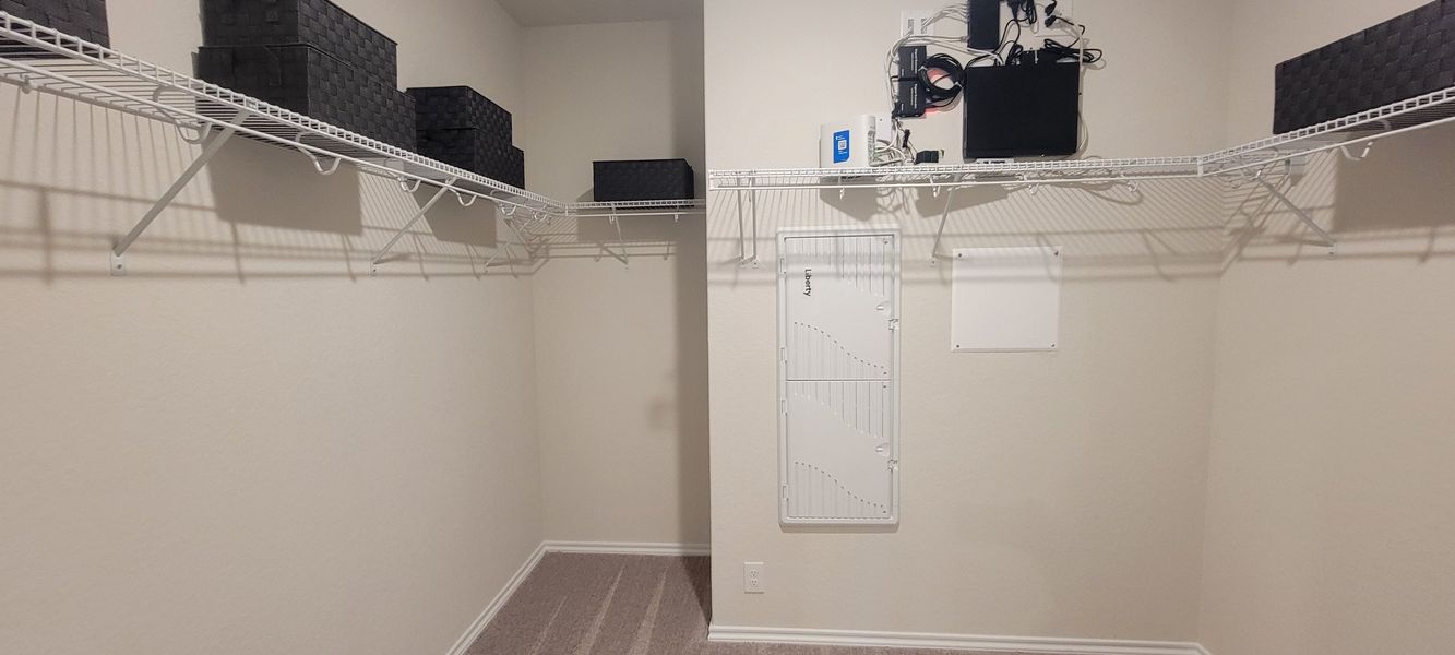 A spacious walk-in closet with organized shelving, perfect for storage and organization. A spacious walk-in closet with organized shelving, perfect for storage and organization.