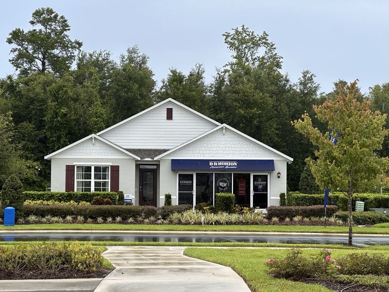 A charming white model home with shutters and a manicured garden in Wynwood by D.R. Horton (Ocoee, FL).