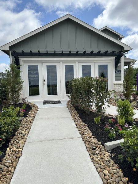 Charming gray home with white trim and lush landscaping in Northpark South by Century Communities (Porter, TX).