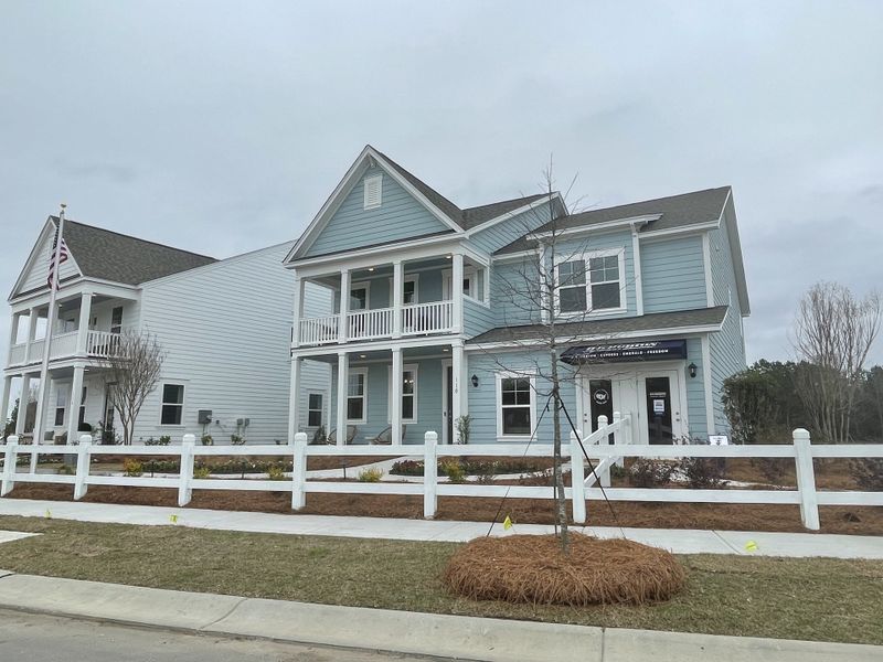 A charming blue home with a welcoming porch and white fence in Sheep Island by D.R. Horton (Summerville, SC).