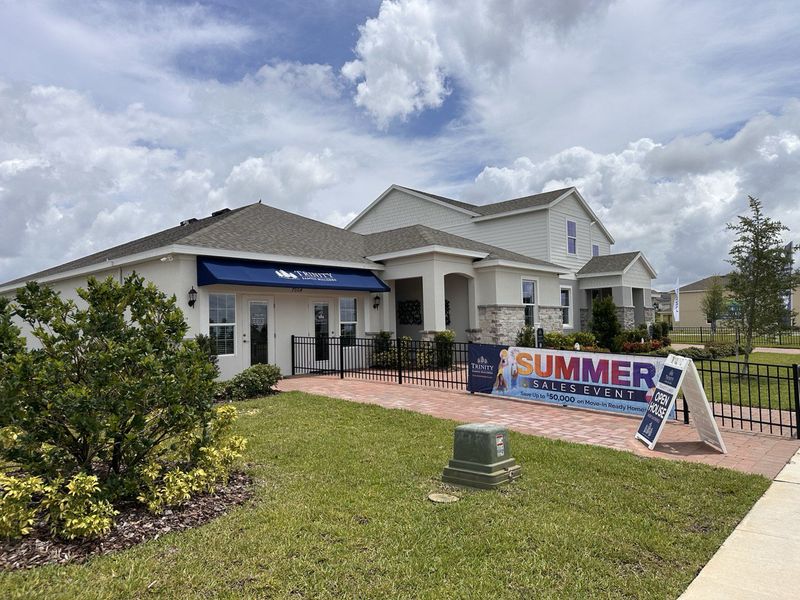 A charming sales office with landscaped garden at Trinity Lakes by Trinity Family Builders in Groveland, FL.