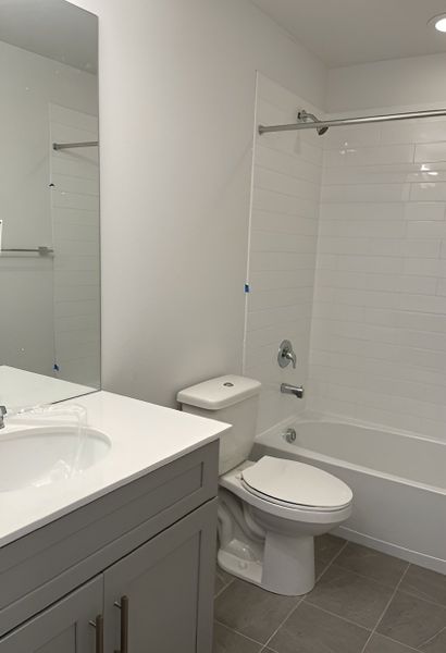 A stylish upstairs bathroom featuring a white subway-tiled shower, a modern vanity, and sleek hardware.