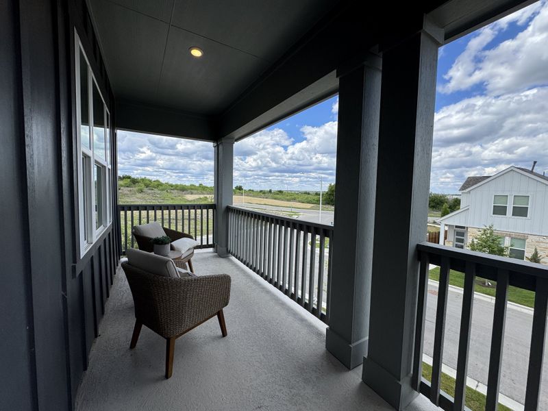 A cozy and inviting balcony with wicker chairs, providing a serene view of the neighborhood.