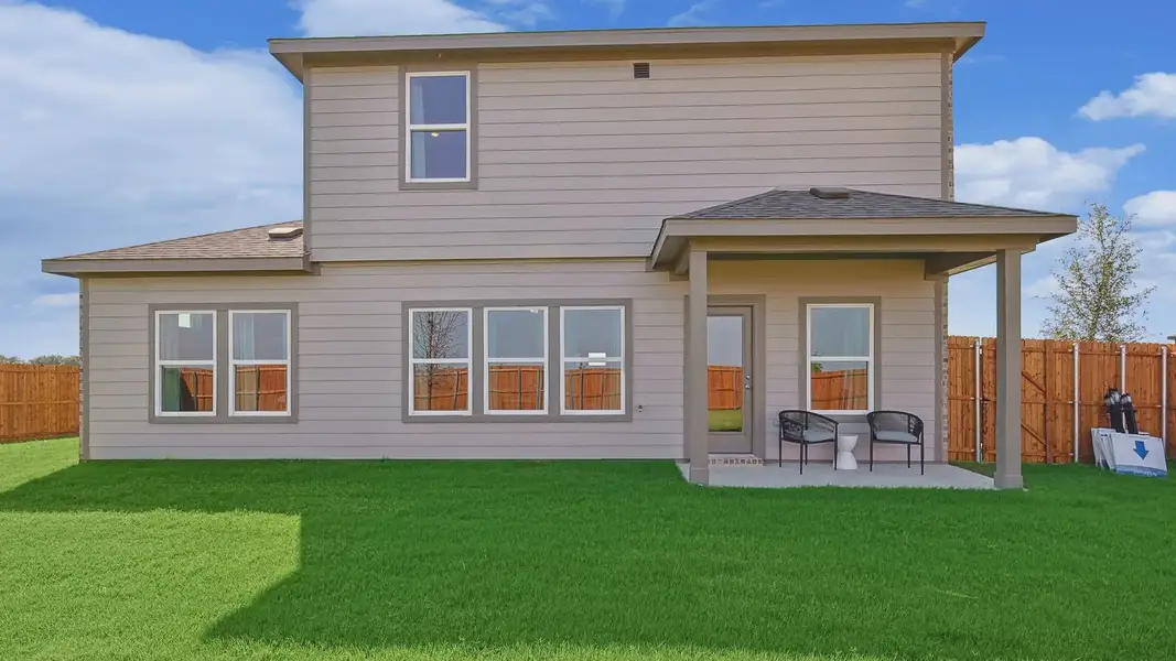 Elegant Patriot Estates residence featuring sleek beige siding and expansive windows, set in a spacious green yard. Elegant Patriot Estates residence featuring sleek beige siding and expansive windows, set in a spacious green yard.