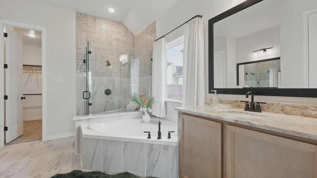Indulge in a spacious marble bathroom with sleek glass shower and custom cabinetry in Westridge.