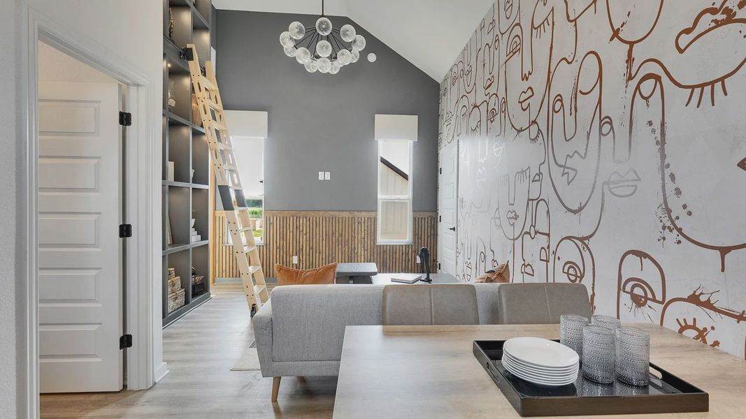 Experience luxury with high ceilings, abstract mural, custom shelving, and elegant chandelier in Spring Creek.