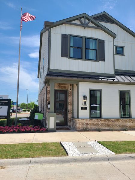 A charming two-story home with a modern facade and manicured lawn in Collin Creek by Ashton Woods (Plano, TX).