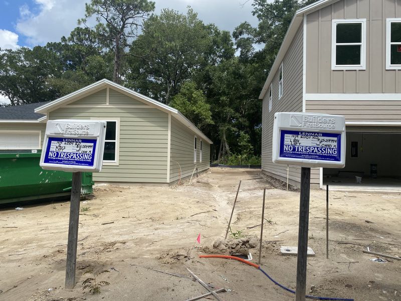 Two homes under construction in Whistler Woods by Lennar, Jacksonville, FL, with "No Trespassing" signs and wooded backdrop.
