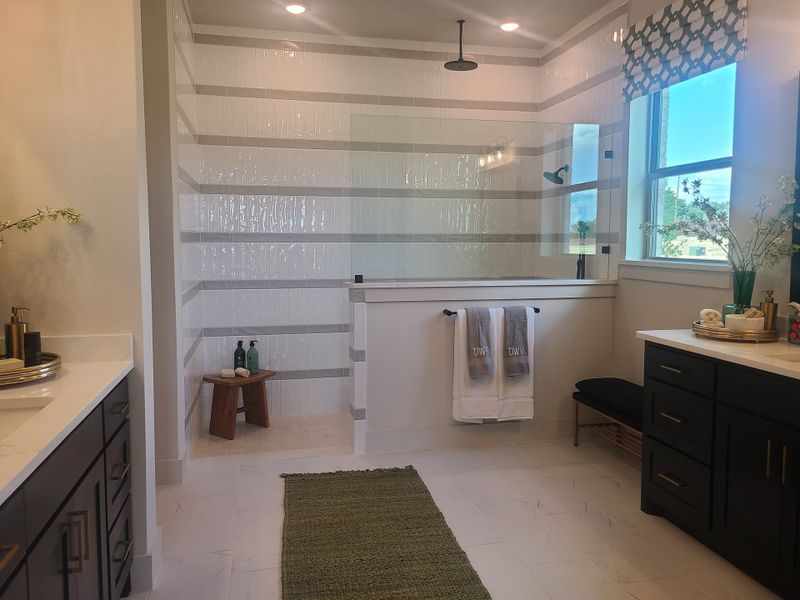 A spacious bathroom featuring a glass-enclosed shower, dark cabinetry, and modern accents. A spacious bathroom featuring a glass-enclosed shower, dark cabinetry, and modern accents.