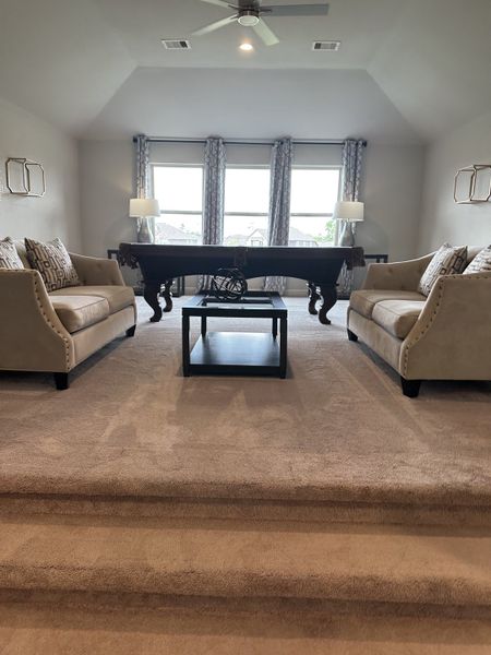 A cozy living area with plush sofas, a game table, and large windows offering natural light. A cozy living area with plush sofas, a game table, and large windows offering natural light.