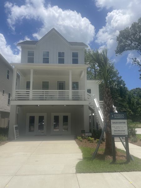 A charming white home with a spacious porch in Indigo Grove Single Family Homes by Stanley Martin Homes (Johns Island, SC).