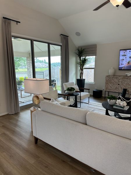 A bright and inviting living room with a cozy couch, elegant decor, and large windows opening to a patio view.