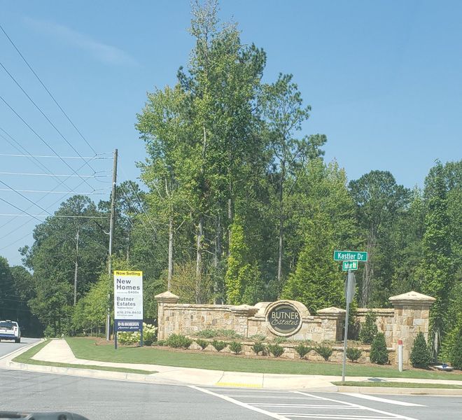 Entrance to Butner Estates by D.R. Horton in South Fulton, GA, featuring a stone sign and lush greenery.