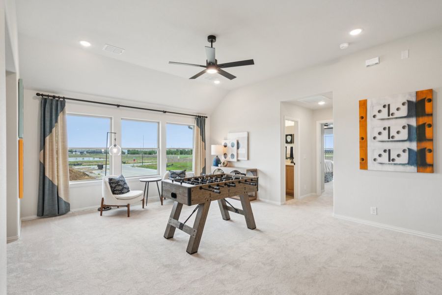 Game room with foosball table, ceiling fan, carpet flooring, and large windows with outdoor views Game room with foosball table, ceiling fan, carpet flooring, and large windows with outdoor views