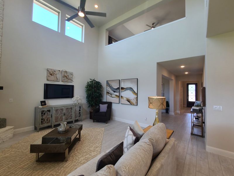 A spacious living room with high ceilings, elegant decor, and a modern aesthetic.