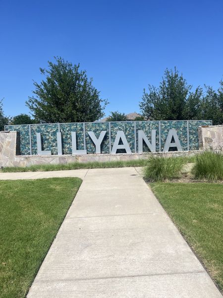Entrance to Lilyana community, crafted by M/I Homes, with lush greenery in Prosper, TX.