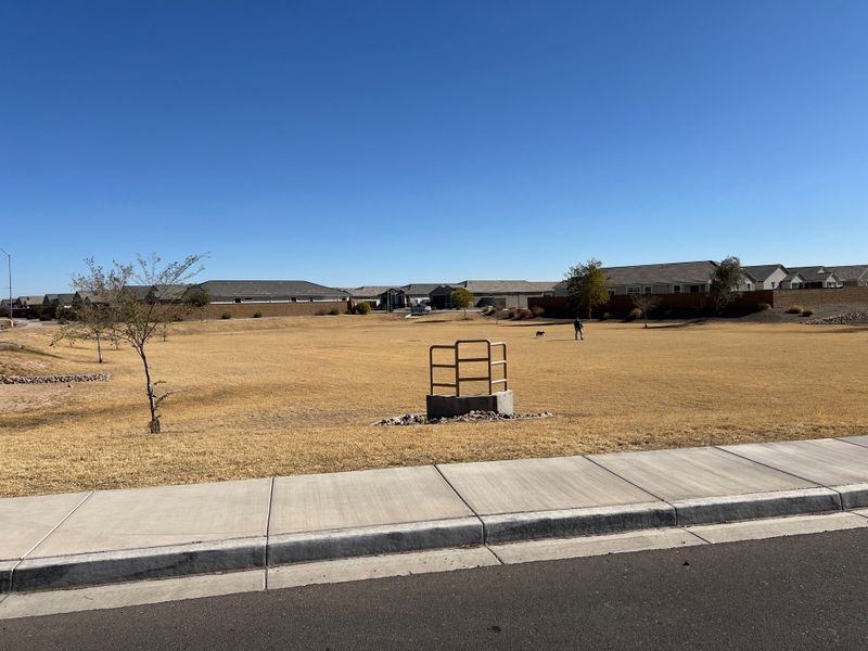Expansive open field with distant homes under clear skies in Tortosa by KB Home, Maricopa, AZ.