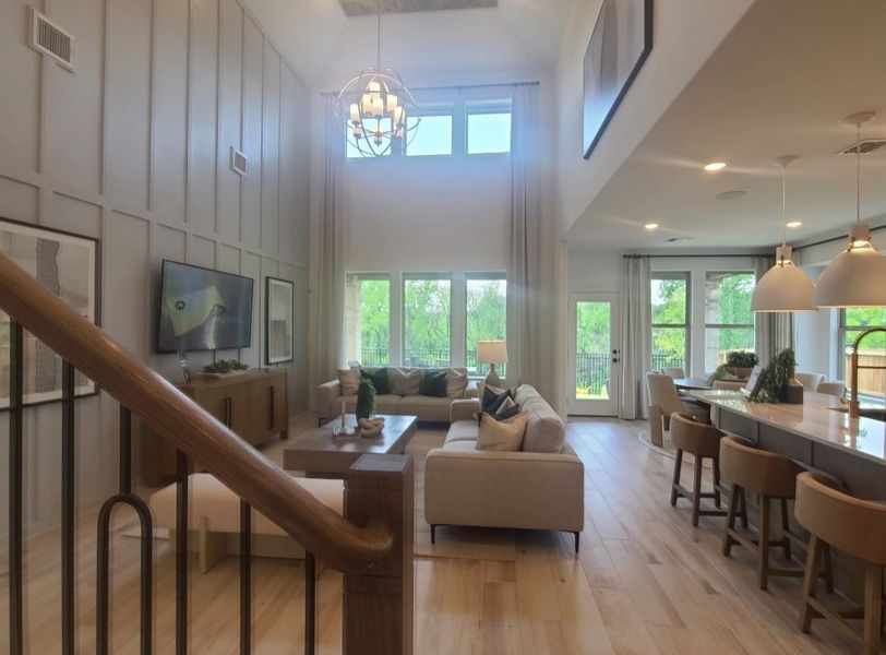 A spacious living area with tall ceilings, large windows, and elegant furnishings, creating a bright and welcoming atmosphere.