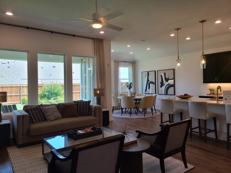 A modern open living space with a cozy sitting area, sleek kitchen island, and elegant dining nook, enhanced by natural light. A modern open living space with a cozy sitting area, sleek kitchen island, and elegant dining nook, enhanced by natural light.