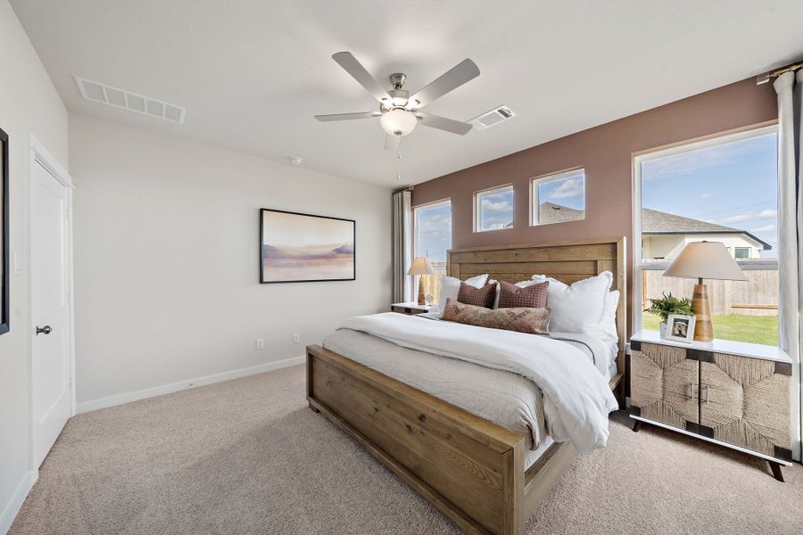 A bedroom with a bed and a fan.