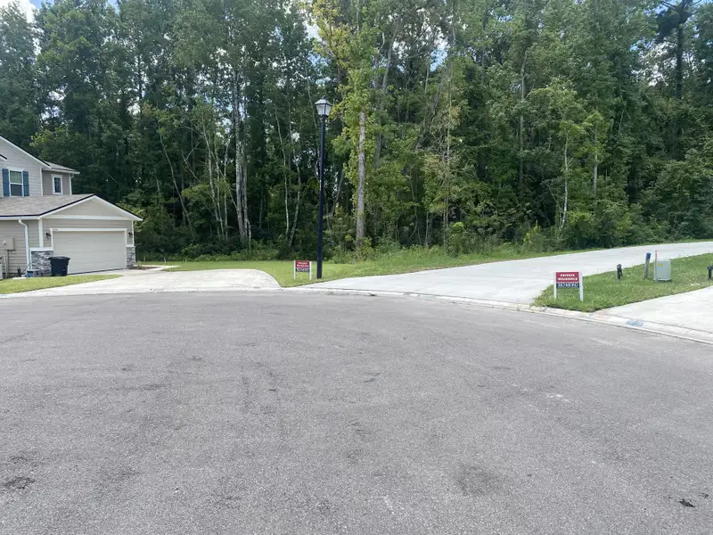 A peaceful cul-de-sac in Seasons at Marietta Cove by Richmond American Homes, surrounded by lush greenery (Jacksonville, FL).