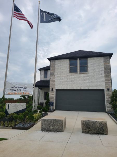 A contemporary brick home with a sleek driveway in Southridge by Trophy Signature Homes (McKinney, TX).