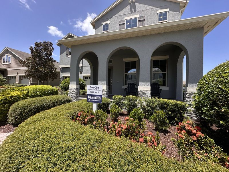 A charming gray home with arched entry and lush landscaping in Waterleigh by D.R. Horton (Winter Garden, FL).